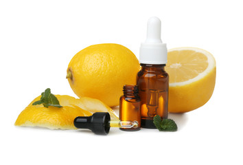 Composition with bottles of lemon essential oil on white background