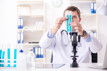Fototapeta premium Male doctor looking at lab results in hospital