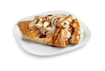Thin pancakes with chocolate syrup, cream and banana on plate against white background