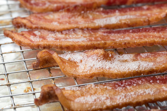 Macro close up on fried bacon strips with foam grease bubbles