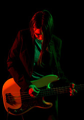 Beautiful rock girl playing bass guitar