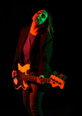 Beautiful rock girl playing bass guitar