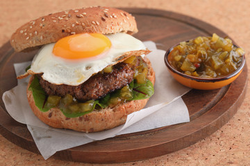 Hamburger with fried egg and gherkin salad