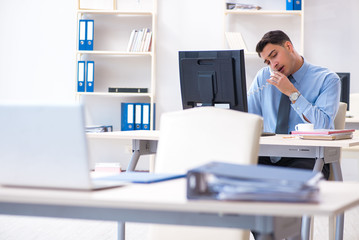 Handsome businessman employee sitting at his desk in office
