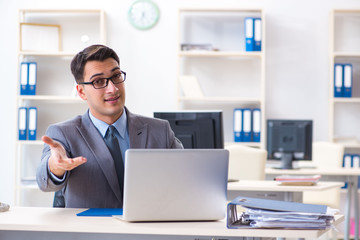 Handsome businessman employee sitting at his desk in office