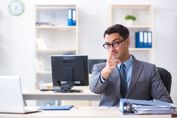 Naklejka premium Young handsome businessman employee working in office at desk