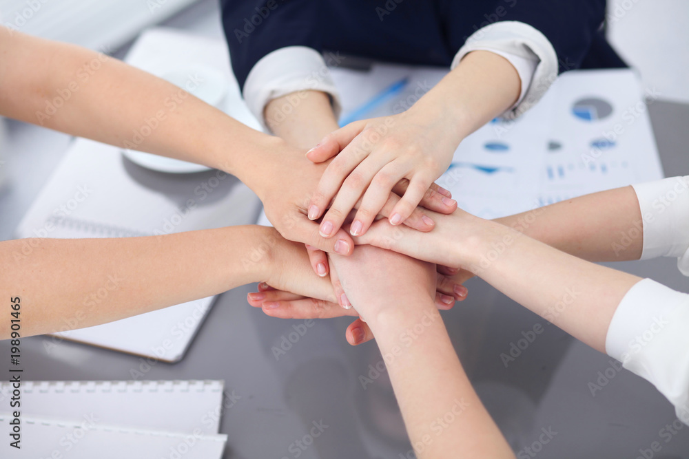 Wall mural close up of unknown business people joining hands. teamwork, cooperation and success concept of peop