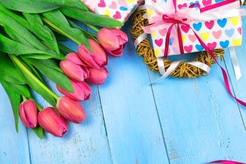 Bouquet of tulips on blue wooden table with gift box. Happy women's day. 8 March., Mother's Day. Flat lay and copy space