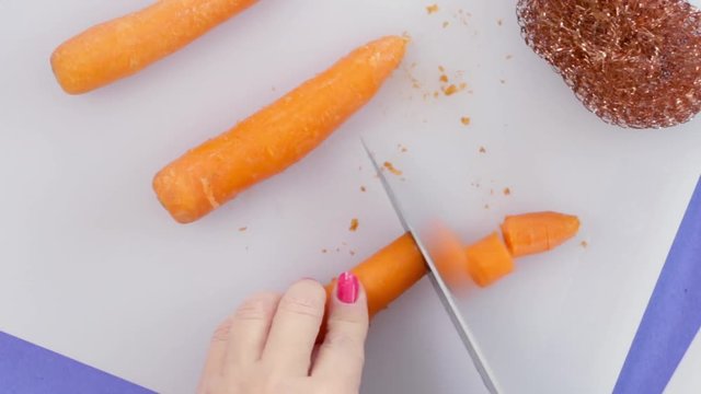 Woman Cleans And Cuts Carrots
