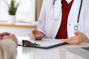 Close up of a doctor and patient hands while discussing medical records after health  examination