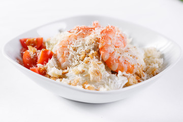 Caesar Salad with Royal shrimps . Comprises iceberg lettuce Leaf and croutons dressed with parmesan cheese. White light background