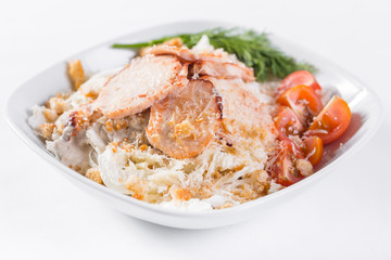 Caesar Salad with chicken . Comprises iceberg lettuce Leaf and croutons dressed with parmesan cheese. White light background