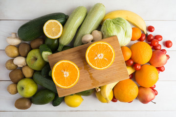 Two part of orange over board and other fruits and vegetables