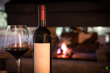 Wine bottle with empty sticker and glass of red wine