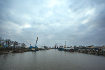 view of the ships on the river and the port with cranes