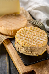 Tasting of oldest french AOC soft pudgent yellow cheese Livarot,  Munster and semifirm Tomme french cheeses