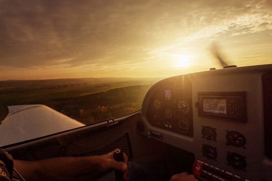 Close up of cockpit of a small airplane during sunset.