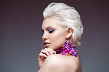 Spring girl with trendy make up smoky eyes . Short clarified hairs, with violet petalsof a tulip on her neck