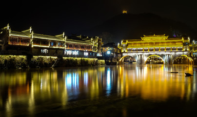 Fototapeta na wymiar Fenghuang, phoenix ancient town, night view with reflections of the town on the river