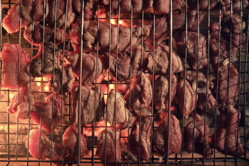 Fototapeta na wymiar Slices of chopped meat in a grate for cooking barbecue on charco