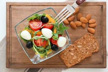 Salad with cherry tomatoes and quail eggs served in glass bowl