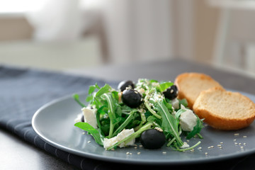 Salad with olives and arugula leaves, closeup