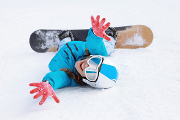 Female snowboarder on ski piste at snowy resort. Winter vacation