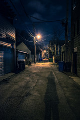 Obraz na płótnie Canvas Shadow of a Person in a Dark City Alley at Night