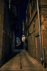 Fototapeta na wymiar Dark and eerie urban city alley at night.