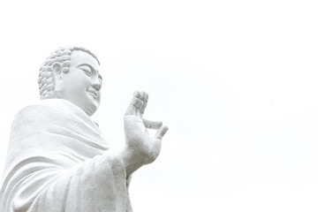 Statue Of Buddha standing with raised right arm gesture of Vitarka Mudra isolated on white....