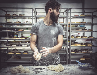 Man posing with dough for preparing donuts,selective focus