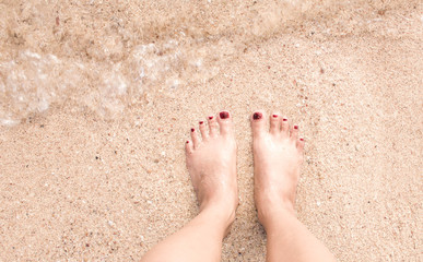 Feet on sand and sea
