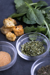 Croutons beside dishes of parsley seasoning and granulated garlic