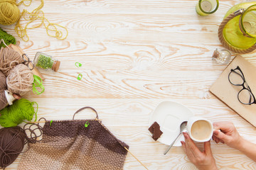 A woman knits a white and broun knitted fabric of woolen yarn. Knitting needles. Aged background....