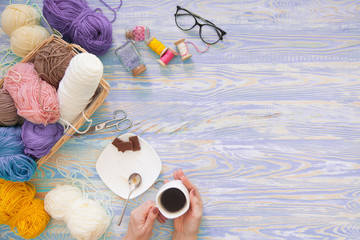 A woman knits a white and broun knitted fabric of woolen yarn. Knitting needles. Aged background....