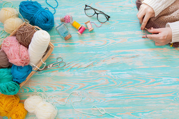 A woman knits a white and broun knitted fabric of woolen yarn. Knitting needles. Aged background....
