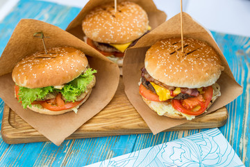 three different sandwiches on a wooden plate