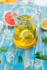 carafe with lemon drink, fruit and mint