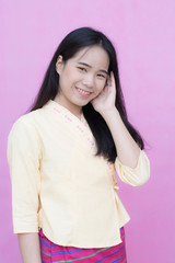 Fototapeta premium Portrait beautiful Asian girl in traditional Thai dress isolated on pink background. .Cotton Dress