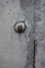 Old screw on construction cement wall. Iron bolt in a concrete wall.