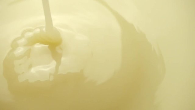 Creamy condensed milk. Pouring sweetened condensed milk. closeup