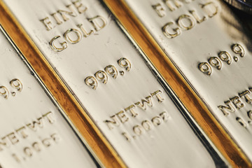 Pure 999.9 shiny fine gold bullions ingot bars, closed up macro shot as financial asset, investment and wealth concept
