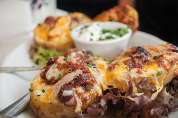 Blurred Background: Chicken Cheese Potatoes with Cheddar-Mozzarella, Garden Salad and Sour .Cream Dip