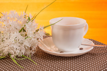Morning tea. A cup of tea and a bouquet of white flowers