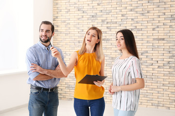 Real estate agent with trainee and client in empty apartment