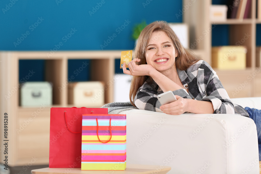 Poster young woman shopping online with credit card using mobile phone at home