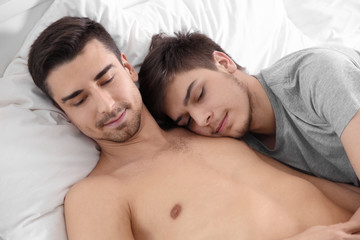 Obraz na płótnie Canvas Young gay couple lying on bed at home