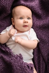 Cute little baby lying on plaid, top view