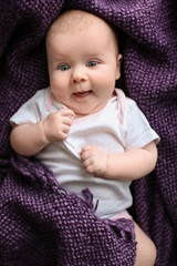 Cute little baby lying on plaid, top view