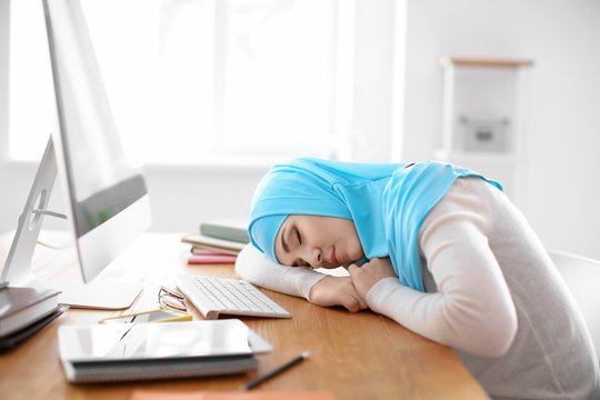 Muslim student in traditional clothes sleeping at table indoors
